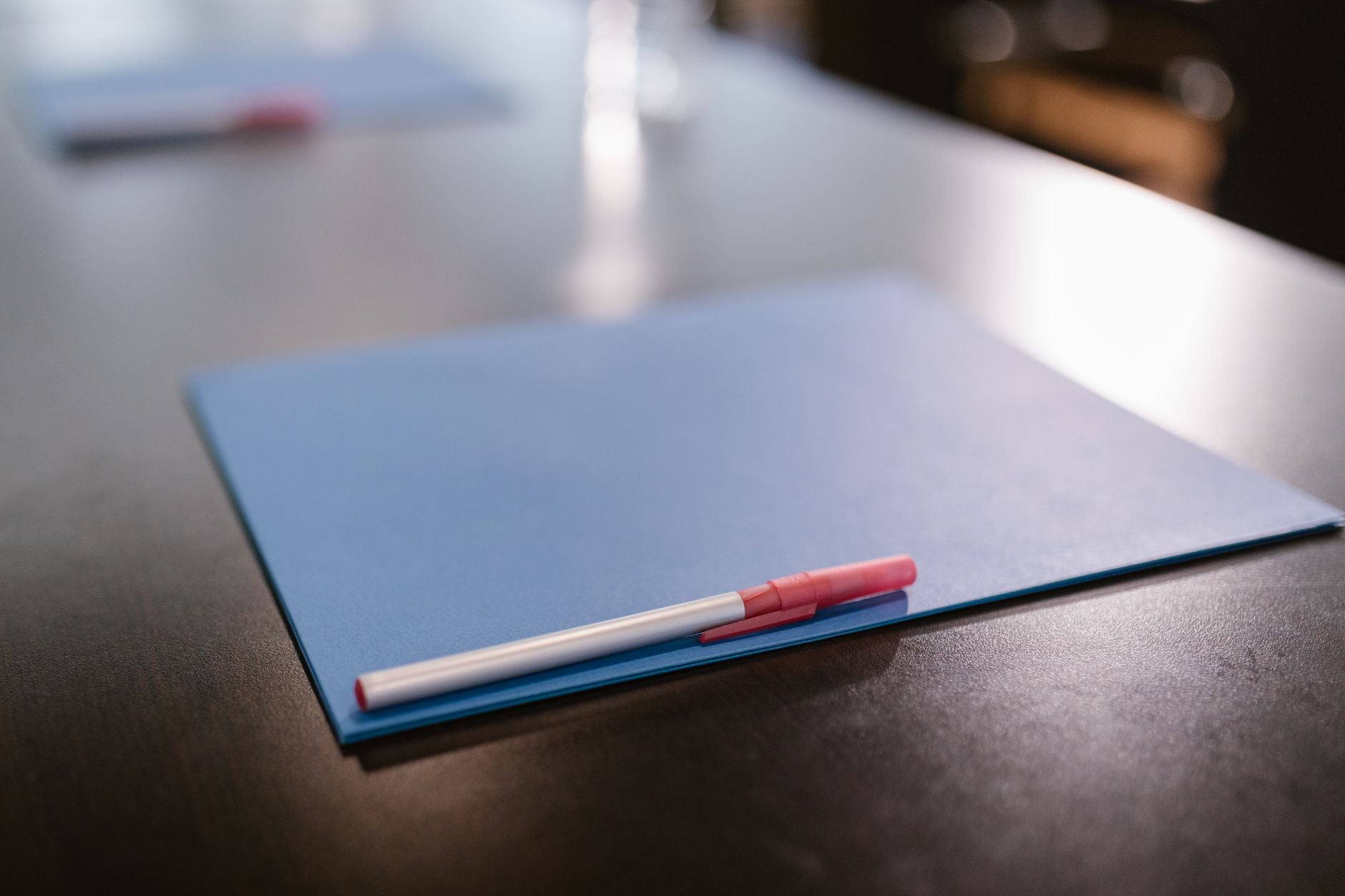 A blue folder and pen on an office table, standing in for scoped deliverables under negotiation.
