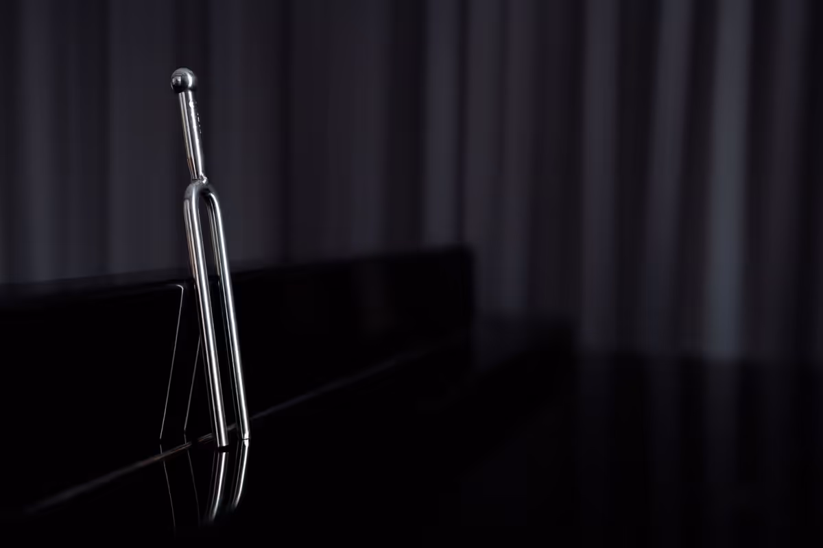 Tuning fork on a desk suggesting aligned human and agent voice.